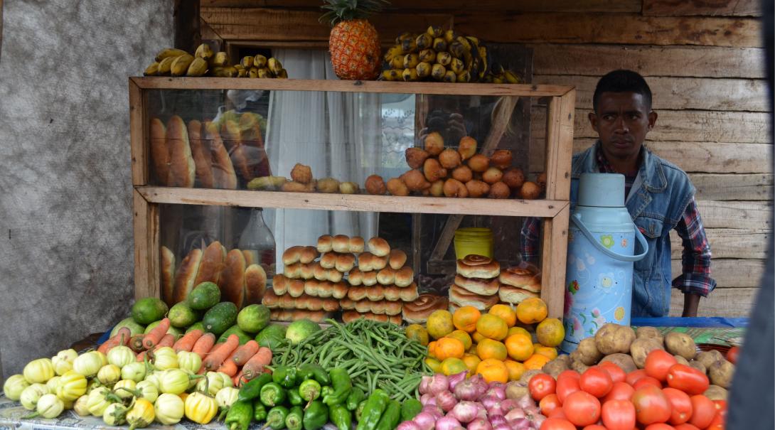 Un commerçant local malgache vendant des fruits et légumes Un magasin local à Madagascar vendant des fruits et légumes de culture bio et des pains végans.